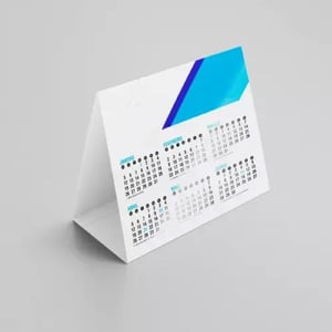 Calendário de Mesa Display Papel Cartão 250g 14,4x9,7cm 4/0 (colorido só frente) UV total  1/0 Corte especial O Prazo de produção começa a contar a partir da aprovação da arte até as 14hs.