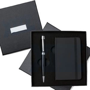Kit Executivo 2 pçs - Ref. 10889 Kit executivo 2 peças em estojo de papelão com tampa e parte interna revestida de espuma. Contém: caneta metal preta com anel e detalhes em prata, caderneta tipo moleskine em couro sintético com aproximadamente 80 folhas amarelas sem pauta. Acompanha  Estojo 17 cm x 17 cm – Caneta 14 cm x 1,6 cm – Caderneta 13 cm x 8 cm    